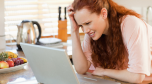 Confused Woman Researching on Laptop in Kitchen