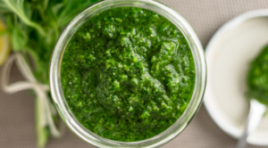 Mason jar of bright green holy basil pesto sauce